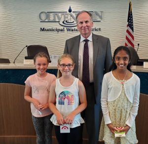 OMWD Board President Larry Watt with contest winners left to right, Ariana Lemle, Emalyn Negrea and Indira Jayanti.