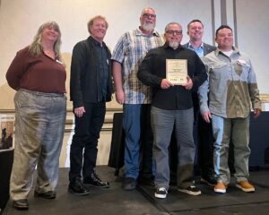 staff on stage accepting award